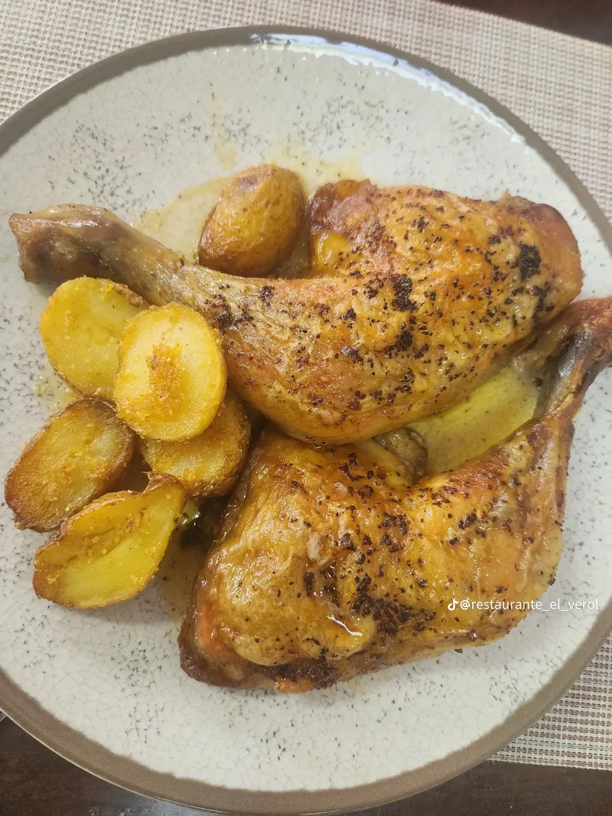 Pollo asado con papas en un plato del restaurante